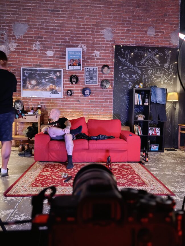 backstage videoclip musicale riprese scena televendita band su divano